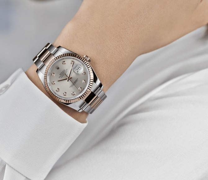An arm in a white shirt with a large silver watch on the wrist